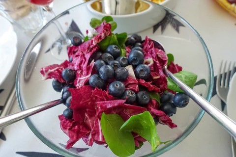 Vegetarian cuisine, salad with blueberries, radicchio (Cichorium intybus var. foliosum), glass