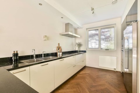 A sleek, modern kitchen showcasing minimalist design. Features include a black counter top, dual
