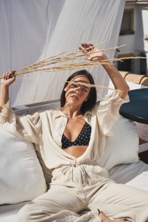 A woman enjoys a sunny day on a stylish rooftop, dressed in casual summer attire She relaxes on