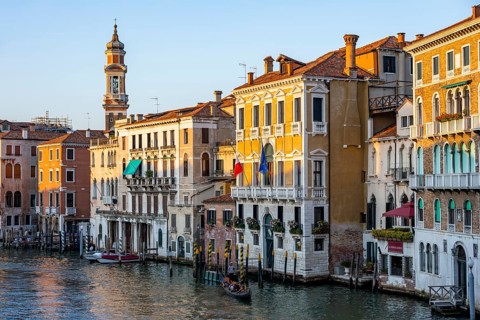 View of the Grand Canal with gondoliers at sunset, picturesque evening mood with palazzos on the