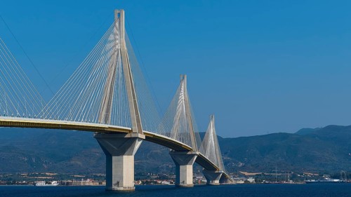 Wide angle view of a long bridge in front of a hilly landscape, Rio-Antirrio cable car bridge,