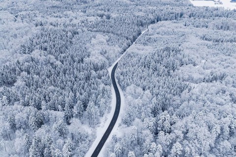 Winding road through snowy winter forest from the air, Gechingen, Calw district, Germany