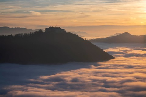 Sunset over the sea of fog from Beurener Fels to Hohenneuffen Castle, Swabian Alb,