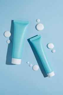 A vibrant image showcasing a cosmetics package with creamy smears on a soothing blue background.