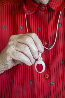 Close up of hand holding life-saving personal alarm for the elderly and disabled people showing
