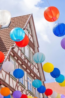 Colourful lanterns float in the sky in front of a half-timbered house, Calw, Black Forest, Germany