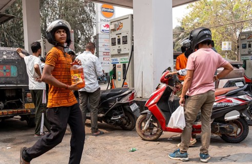 A fuel station attendant refuels vehicles at a petrol pump in Guwahati, India, on March 11, 2026.