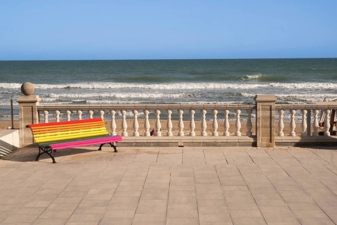 Empty colourful bench on the promenade in Sitges, Spain