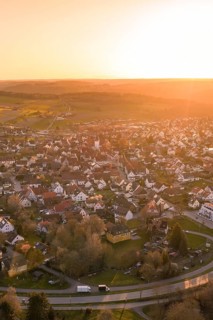 Aerial view of picturesque village at sunset with warm light and surrounding landscape, Calw,