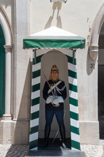 A guard in traditional uniform stands in a guardhouse, guard in the Barrio Alta and Chiado