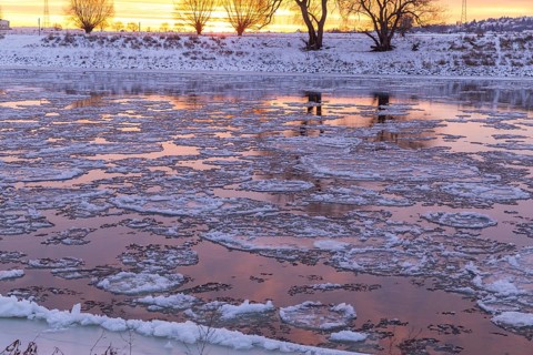 Cold winter morning on the Elbe with floating ice floes, snow and dawn at sunrise, Kötzschenbroda,