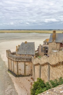 View from above of Mont Saint-Michel in a wide coastal landscape with sand and sea, Le