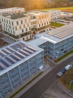 Modern building with solar panels next to a road in an industrial area, new construction of the