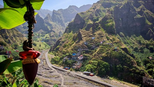 View from a banana tree (musa) over a village and a mountainous landscape, hike in the Paul Valley,