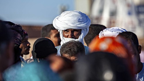Male person with turban in a crowd at a market place, The traditional Tuareg at the Tamanrasset