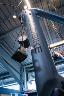 Dark blue bicycle frame with Waldbike lettering in a modern workshop, Waldbike Manufaktur, bicycle