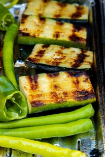 Grilled courgettes and green peppers with grill strips on a barbecue