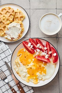 Top view of a delightful homemade breakfast featuring a fried egg topped with feta cheese and fresh