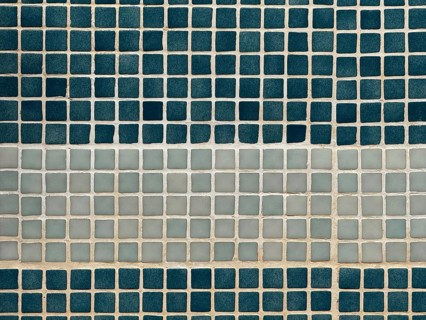 A close-up view of a wall featuring a pattern of square tiles. The arrangement includes alternating