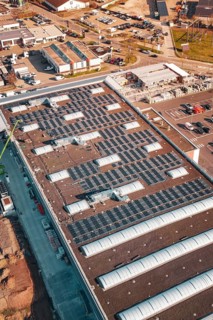 Industrial building with numerous solar panels on the roof in an urban environment, PV Bau Auf OBI