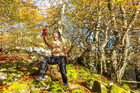 A woman enjoys a scenic autumn hike in Gorbea Natural Park, Basque Country, Spain. Surrounded by