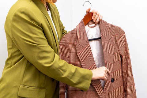An image consultant assists a client in selecting a stylish jacket, emphasizing personalized