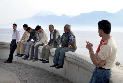 Antalya, TUR, 10.04.2004 - Turkish men sit on a wall on the waterfront in Antalya, Turkey. In the