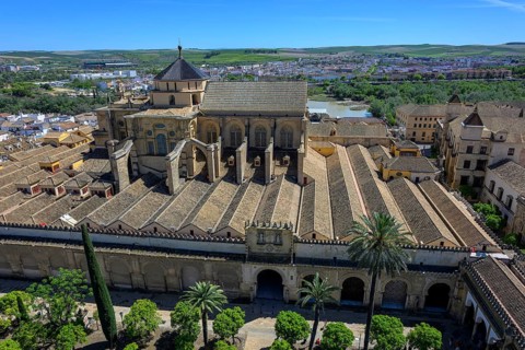 Panoramic view of the Cathedral Mosque of Córdoba, Mezquita-Cathedral, with surrounding palm trees,