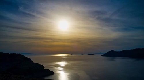 Drone shot, landscape with sunset over calm water and islands on the horizon, Holy Week, Bay of