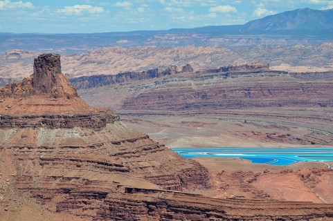 Sublime rock in the foreground of a canyon landscape with turquoise salt pools, Dead Horse State