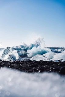 Captivating ice formations on Diamond Beach, Iceland, contrast against the black sand, with waves