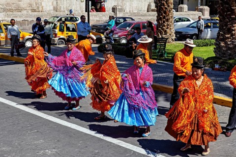 Dancers in colorful costumes offer a lively performance on an urban street, a colorful dance and