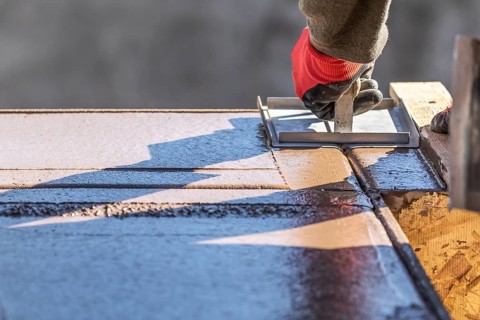 Construction Worker Using Hand Groover On Wet Cement Forming Coping Around New Pool