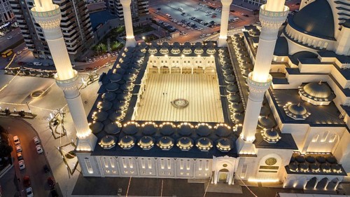 Aerial view captures hundreds of Muslims gathered at long tables for a communal Iftar meal in a