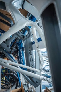 White and blue bicycle frames in a workshop with a view out of the window, Waldbike Manufaktur,
