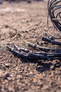 Close-up of cables and plugs on a gravelly surface, PV installation at OBI Baumarkt, Mühlacker,