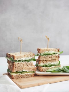 Sandwiches with cucumber and green spinach, stacked and cut in half