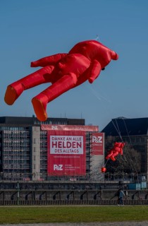 A construction company has hung a large poster on a building facade on the Rhine promenade,