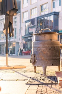 Retro metal pot in an old town street next to a café, Sindelfingen, Böblingen district, Germany