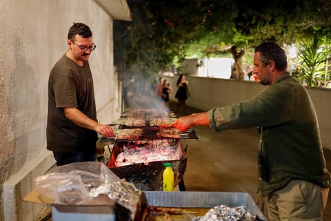 Two men grilling meat at a night street party, festival, Panagia Kamariani, Megalo Chorio, Zero
