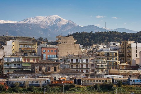 City skyline with densely built houses and snow-capped mountains in the background, old ferry port