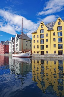 A boat is moored in a harbor flanked by colorful buildings reflecting in the water, Art Nouveau