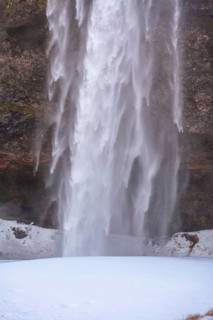 Detail of Seljalandsfoss waterfall with snow in winter in Iceland
