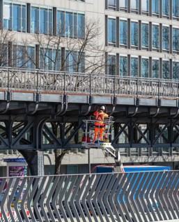 Construction worker surveying the elevated railway along the Elbe promenade, Hamburg, Germany
