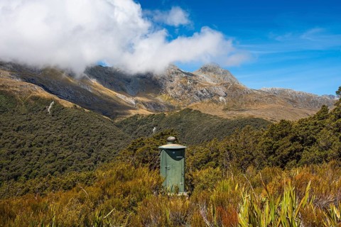 Toilets can be found on many hiking trails in New Zealand. Mountain scenery on the Key Summit Track
