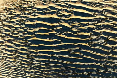 Aerial view of textured sand in La Puna desert, showcasing intricate patterns formed by natural