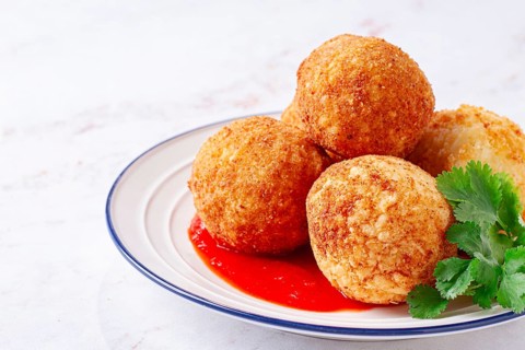 Arancini appetizer with tomato sauce, on a white plate, homemade, no people
