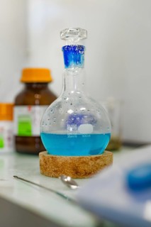 A flask of blue liquid stands on a cork in the laboratory, Nagold Youth Research Centre, Black