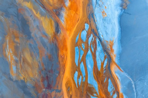 A captivating aerial photograph showcasing a vibrant abstract landscape with flowing forms and a