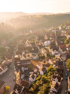 A village with numerous buildings and a prominent church surrounded by hills photographed from the